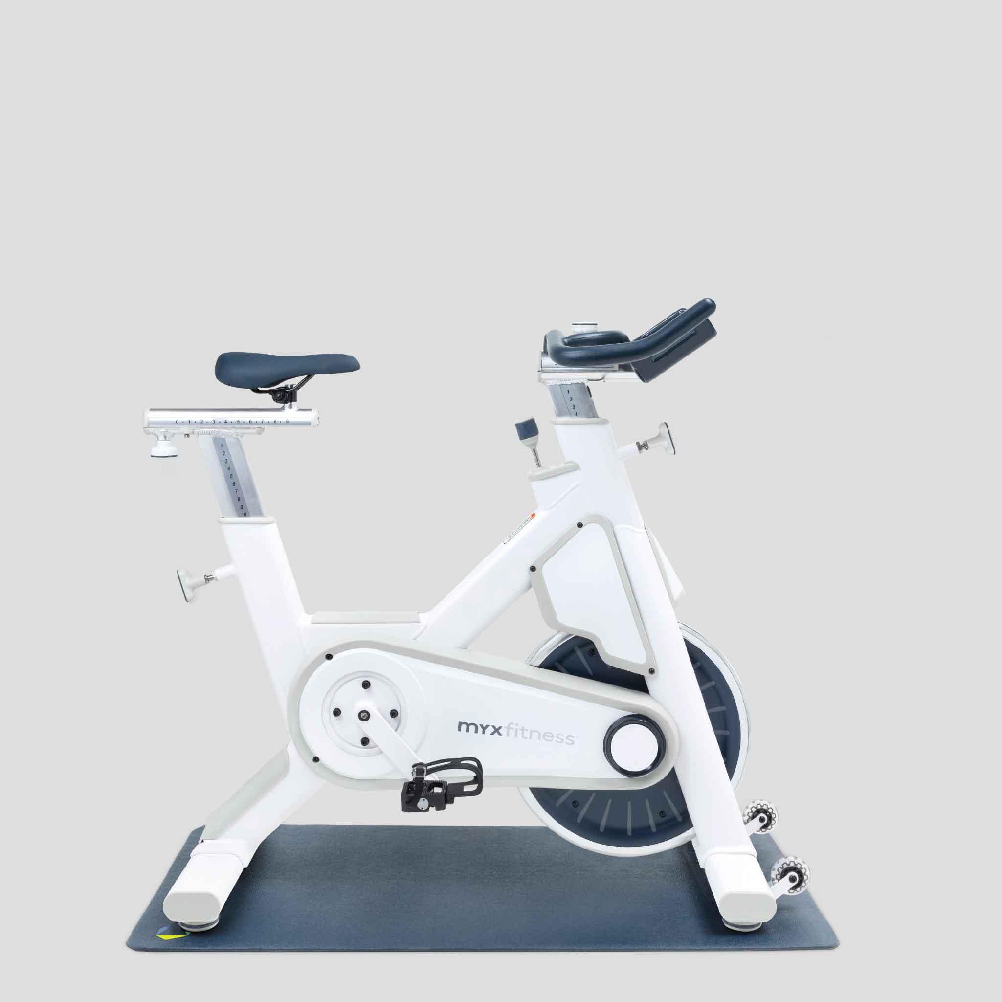 The BODi Bike+ Home Studio in Natural White with weight rack, foam roller, spri stretch band, kettlebell and floor mats